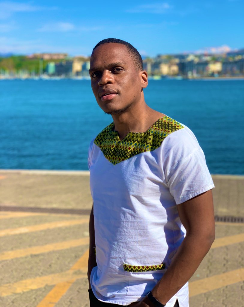 Bongani Ncube-Zikhali in traditional-trim attire on the shore of Lake Geneva
